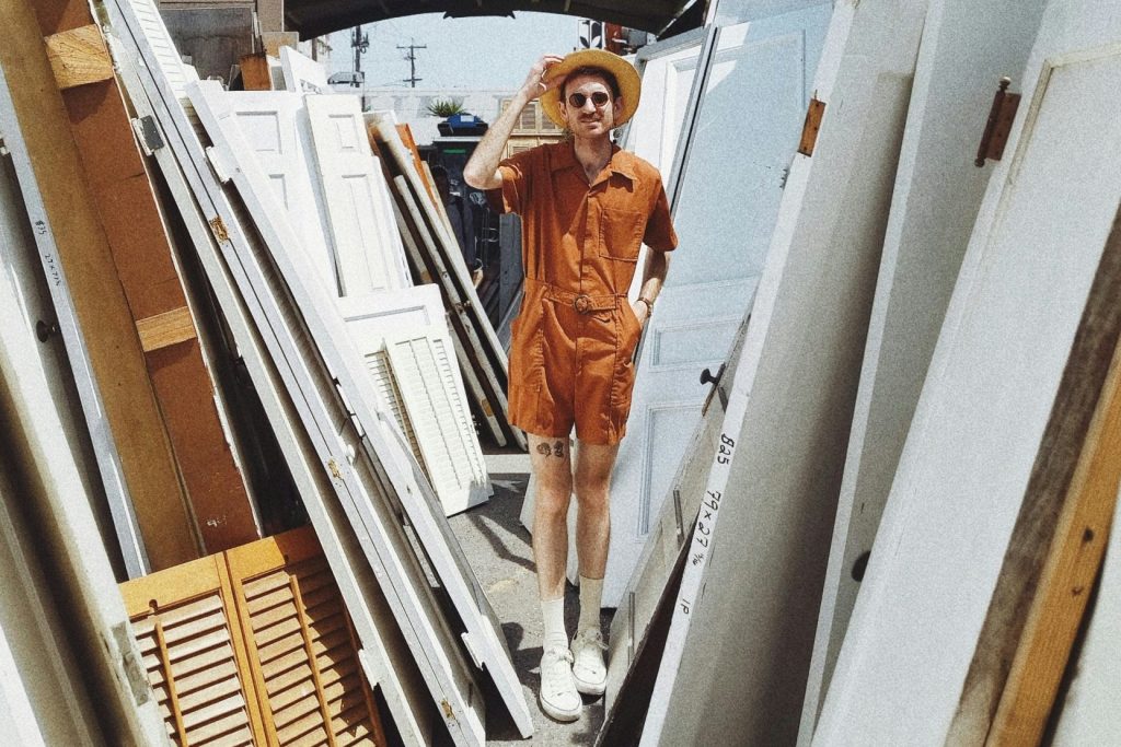 person standing beside white wooden panels