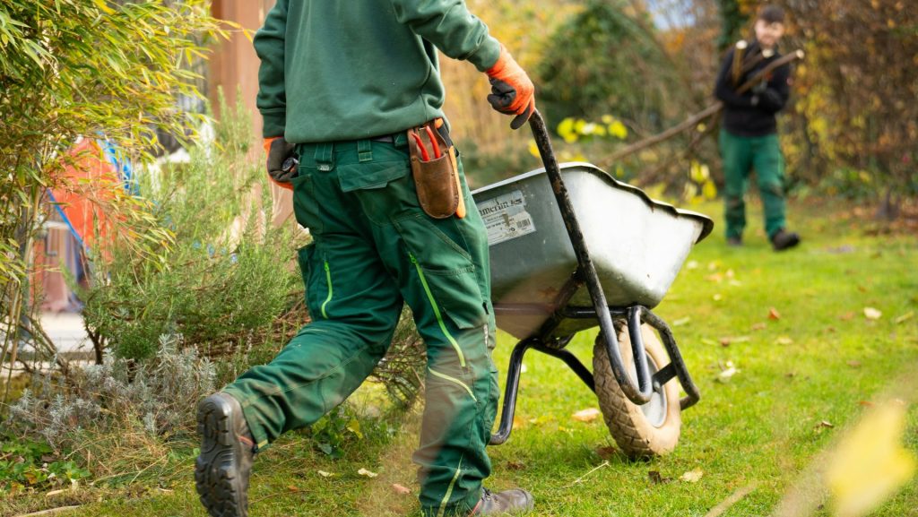 A man pulling a wheelbarrow with a wheel